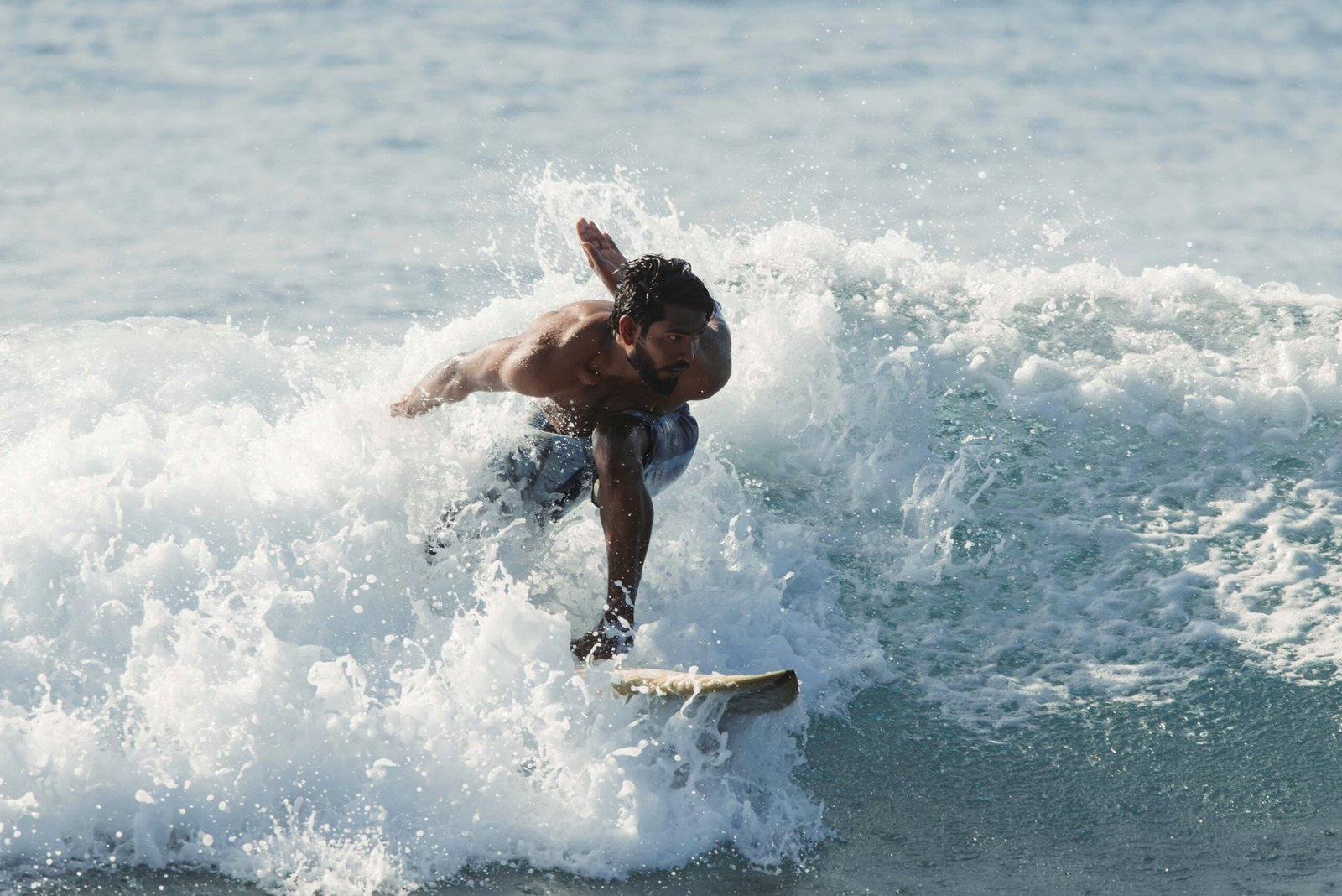 Man wearing Bénieller UV‑protective swim trunks made from recycled materials on a sunny beach.